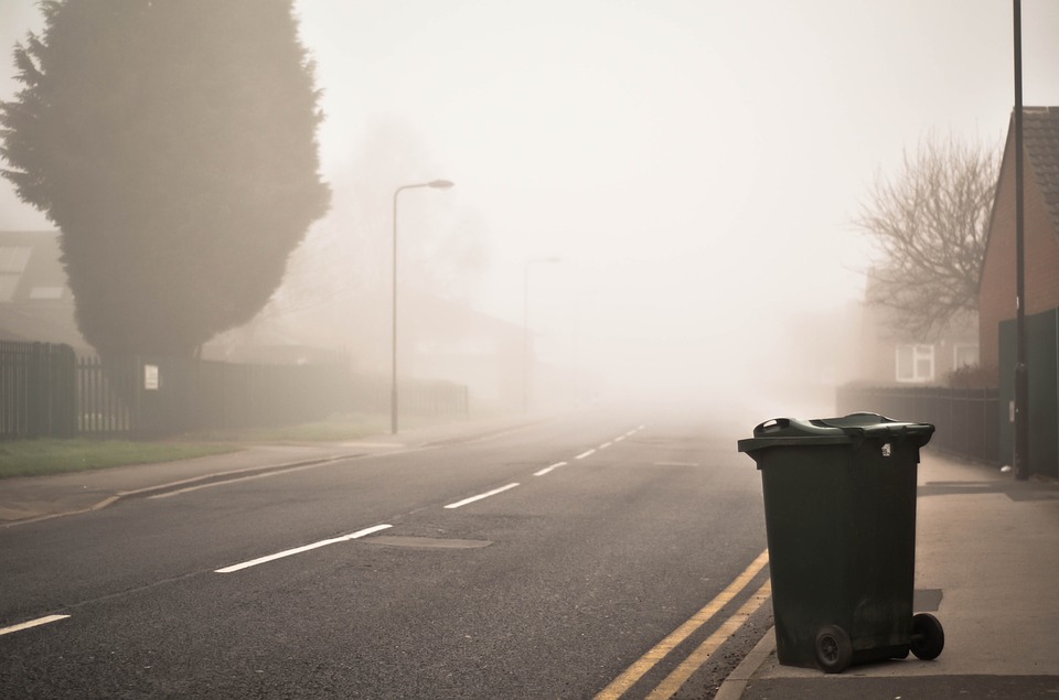 a road with a garbage can